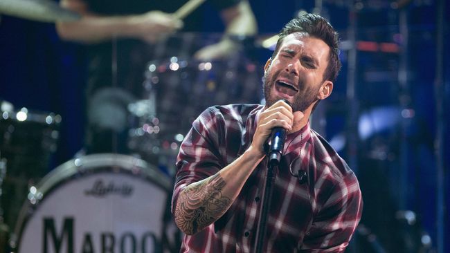Adam Levine, vokalis Maroon 5, tampil energik di atas panggung dengan sorotan lampu yang memukau.