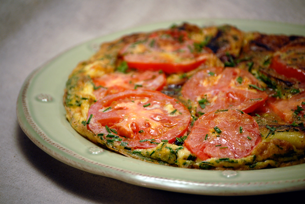 A golden-brown potato omelet served on a rustic plate, garnished with fresh herbs for a burst of flavor