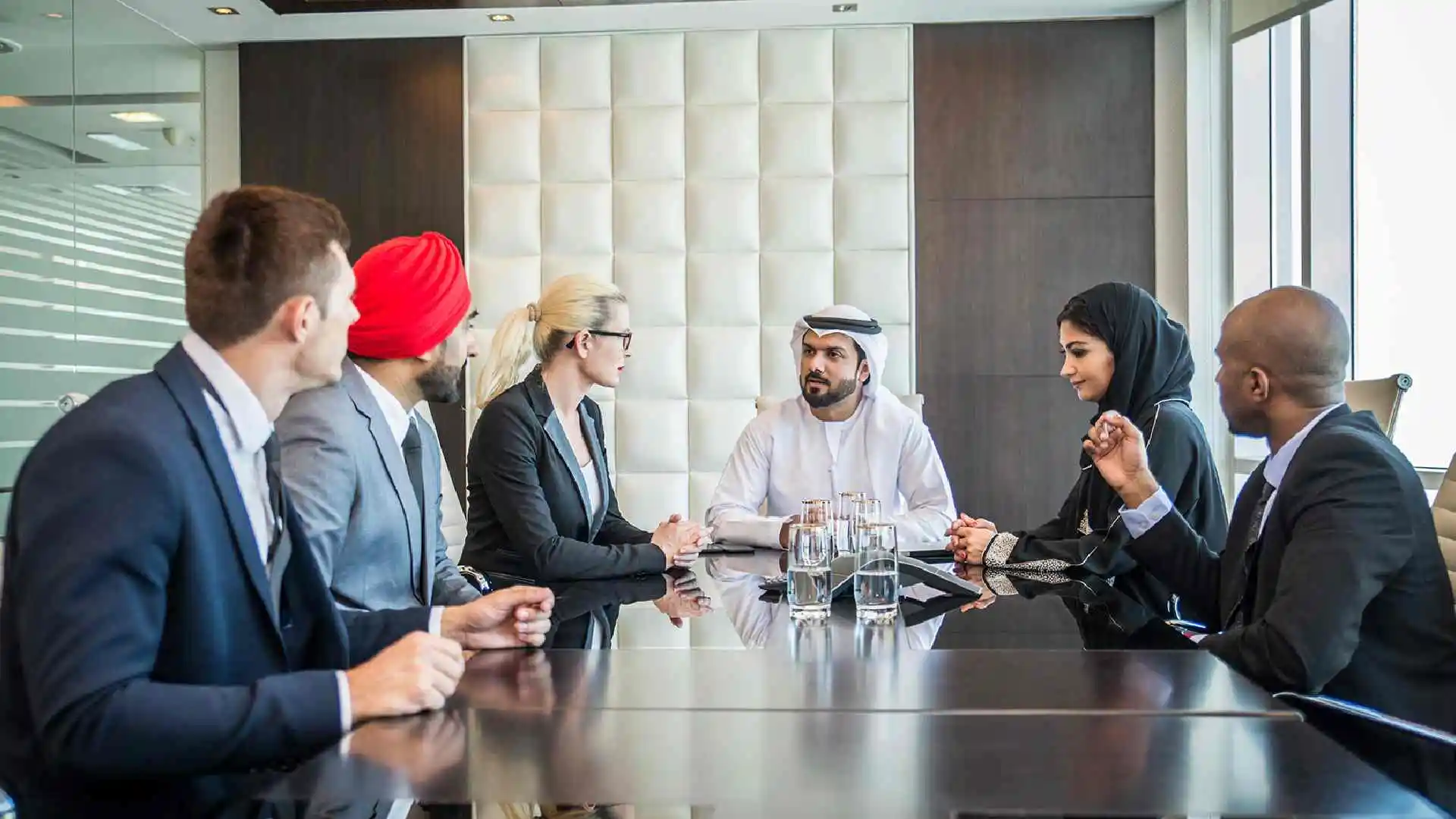 Business executives networking at a conference in Dubai, highlighting the city's role as a hub for international business events.