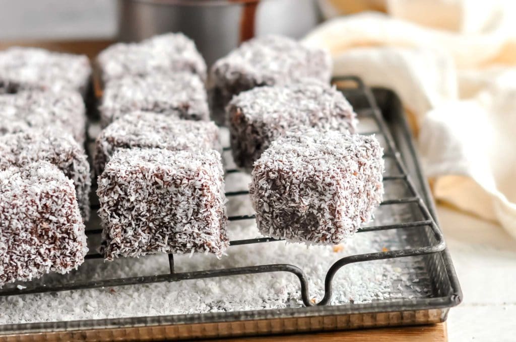 Assorted Lamingtons with variations including jam-filled and raspberry-flavored.