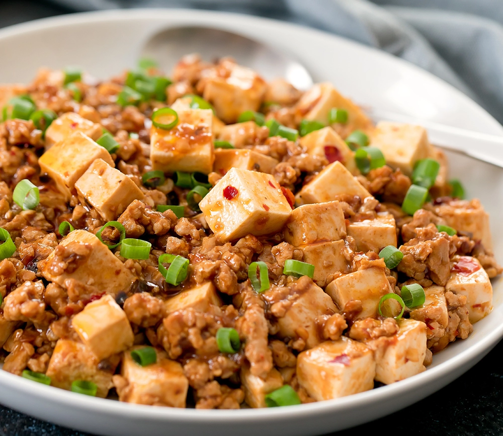 Ma Po Tofu served with steamed white rice and garnished with green onions 