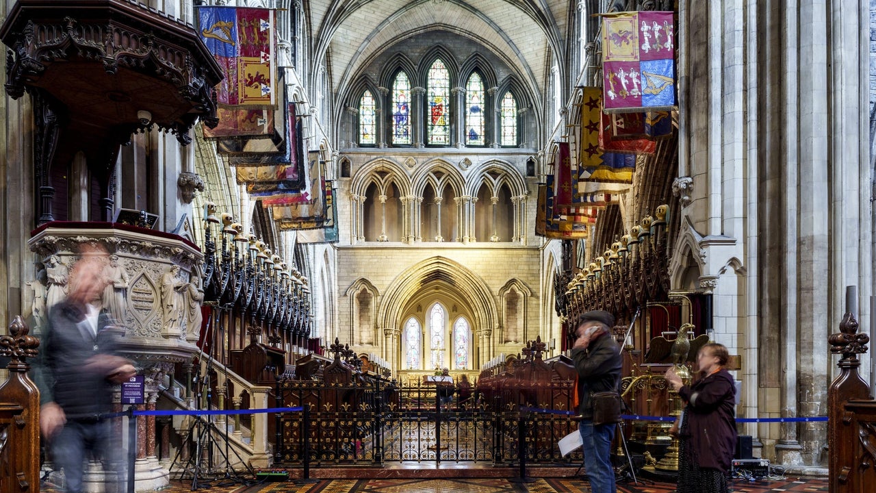 The stunning interior of St. Patrick's Cathedral with high vaulted ceilings and intricate stained glass windows. 