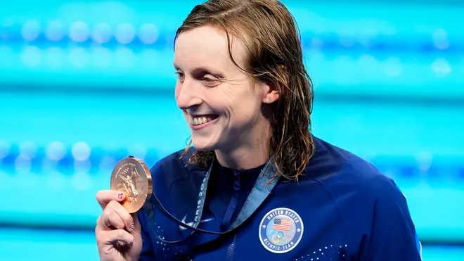 French athlete celebrating gold medal at the Paris 2024 Olympics.