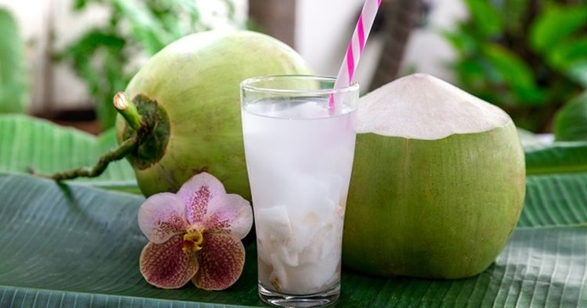 Es Kelapa Muda segar disajikan dengan es batu dan sirup gula merah, sempurna untuk melepas dahaga di cuaca panas